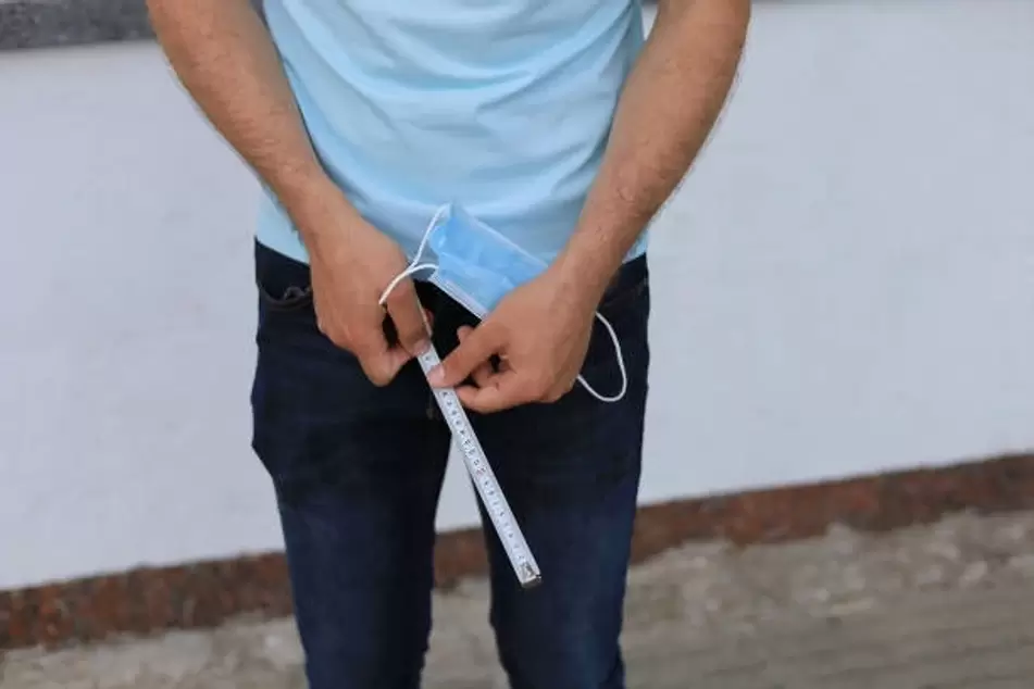 the man measures the size of the penis before enlargement