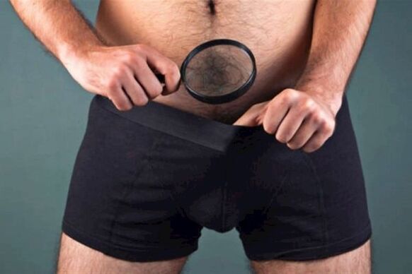 a man examines his penis with a magnifying glass and wants to enlarge it
